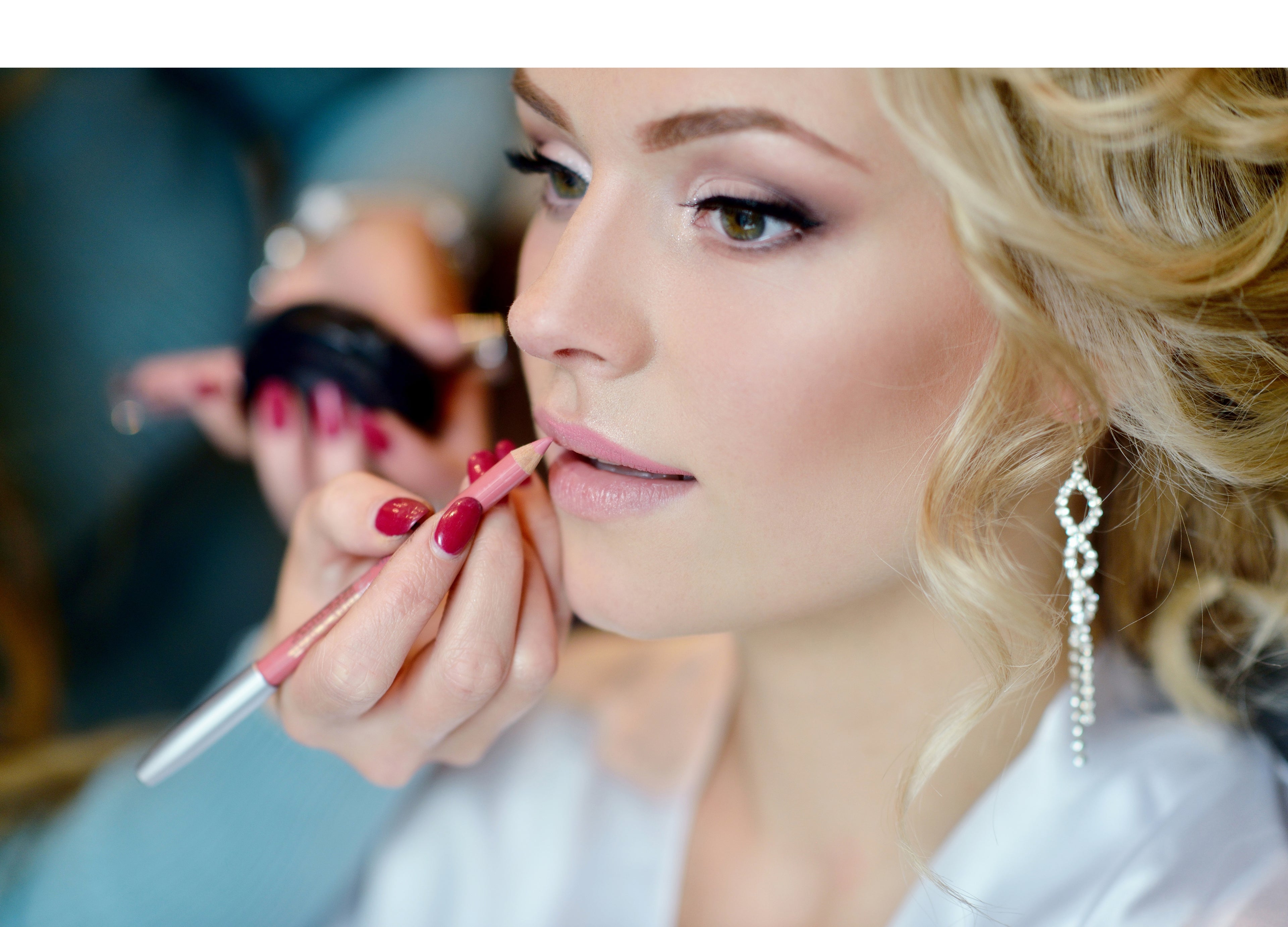 gestylte Braut, die gerade Lippenstift aufgetragen bekommt