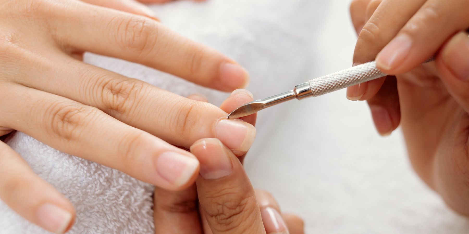 Schönheitsbehandlung: Nahaufnahme von Händen bei der Nagelpflege