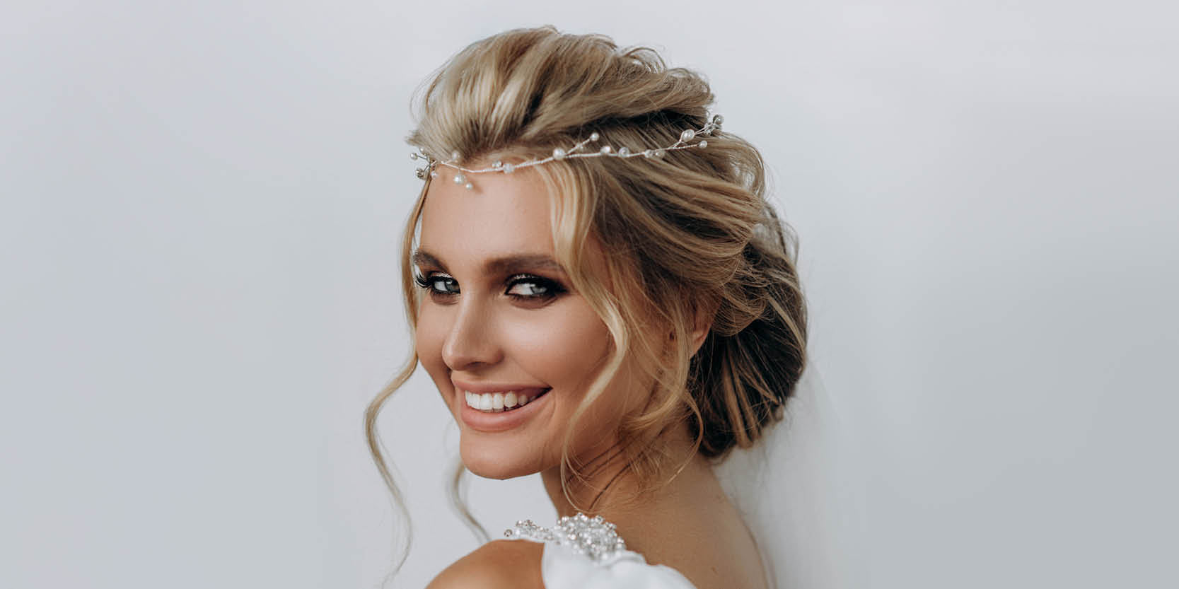 lächelnde Braut mit perfektem Make-up und Haarstyling