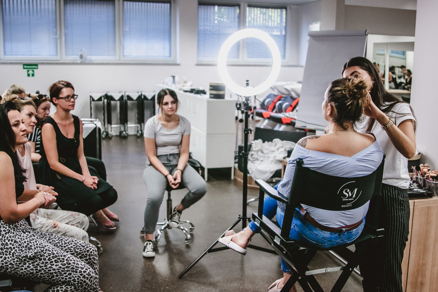 Dozentin beim Schminken eines Models vor Schülerinnen in der German Beauty Academy