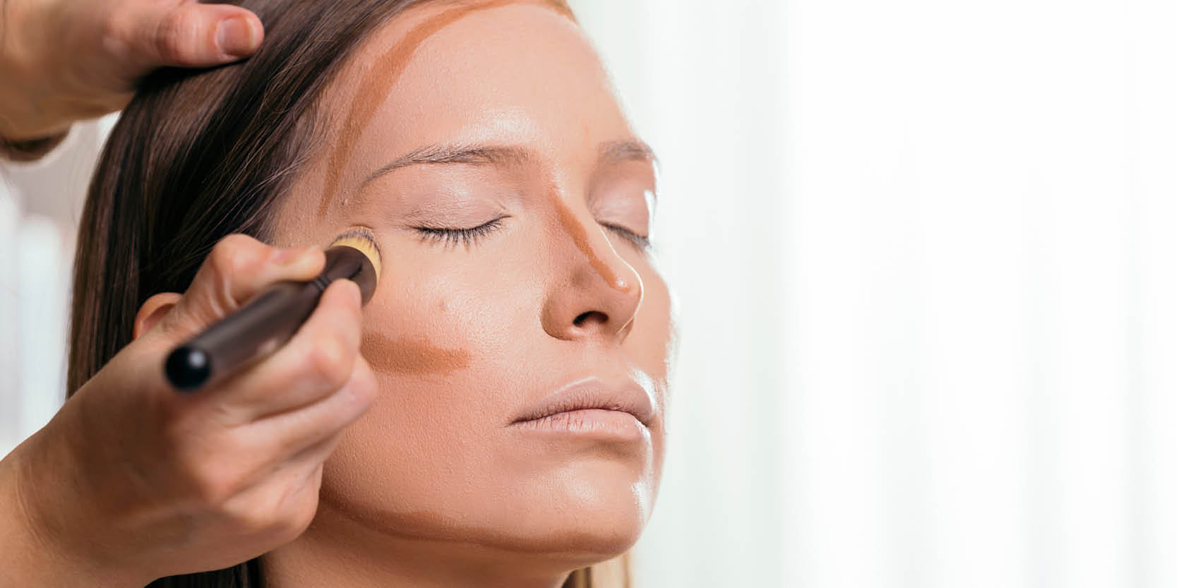 Schönheitsbehandlung: Model wird Basis Makeup mit Pinsel aufgetragen