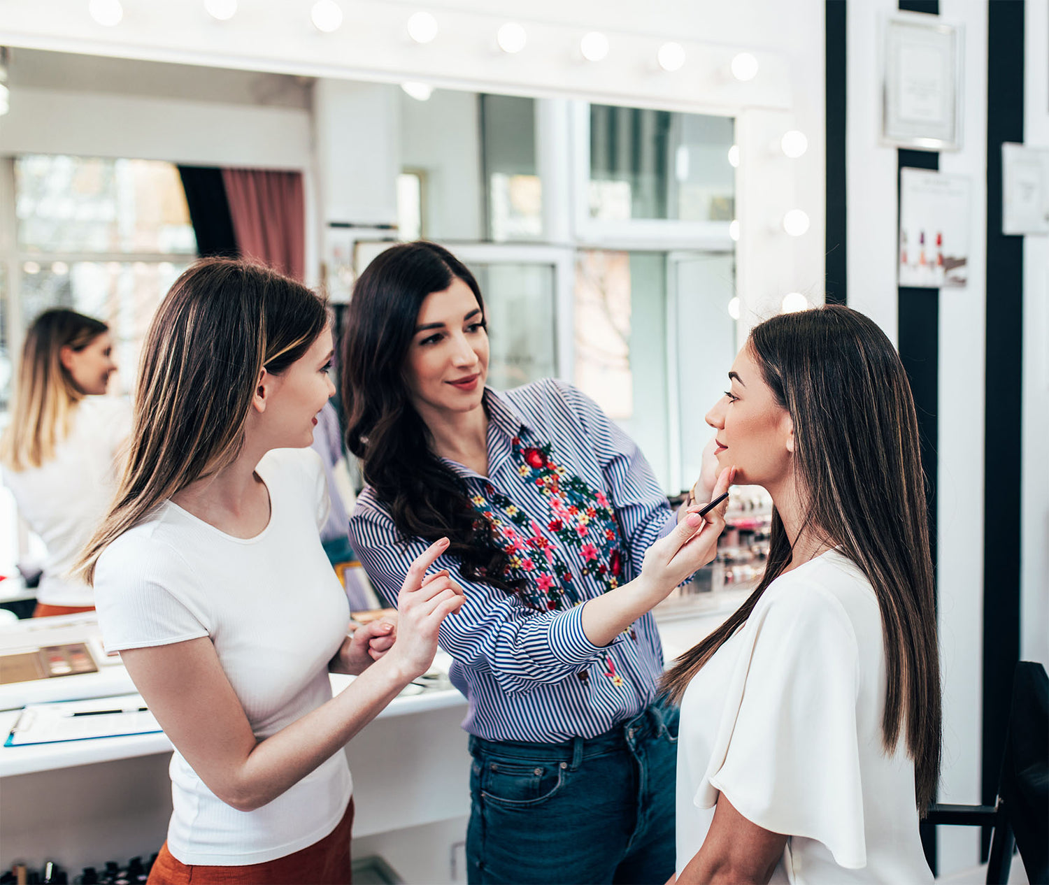 Kosmetiktrainerin überprüft das Make-up Model einer Schülerin