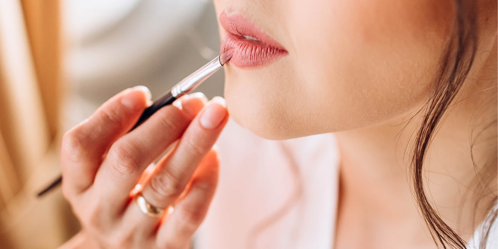 Nahaufnahme von Lippen, auf die roter Lippenstift aufgetragen wird