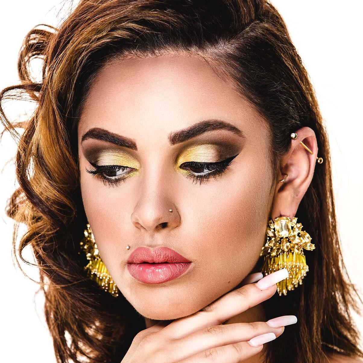 Extravagant geschminkte Frau mit goldenem Make-up, kunstvoll inszeniert im Rahmen eines Visagisten- und Make-up Artisten-Kurses der German Beauty Academy – leuchtende Highlights, kreative Akzente und glamouröses Styling.
