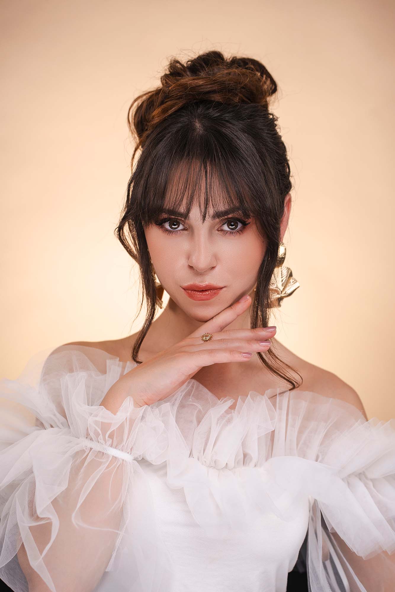 Portraitfoto eines bildhübsch geschminkten Models in weißer Kleidung