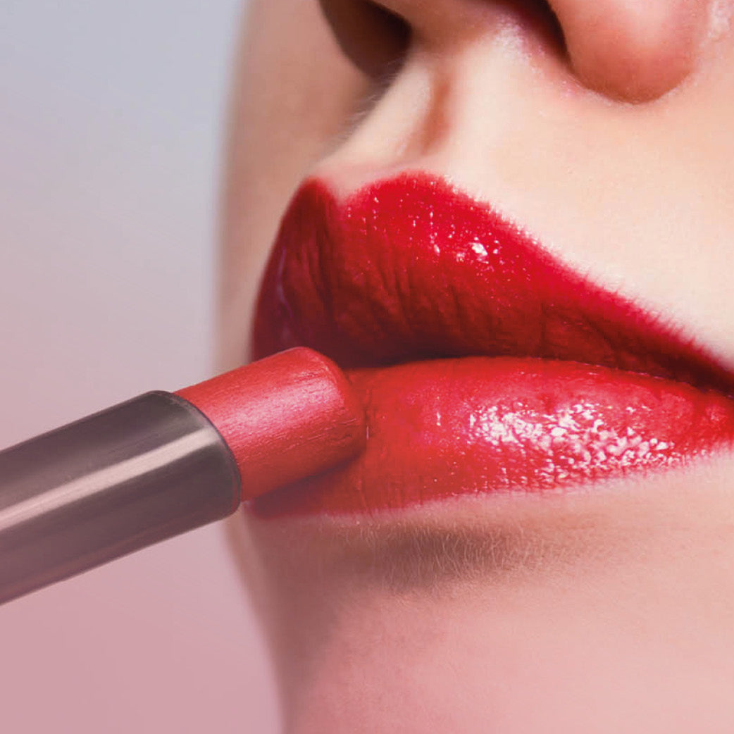 Nahaufnahme von Lippen, auf die gerade roter Lippenstift aufgetragen wird
